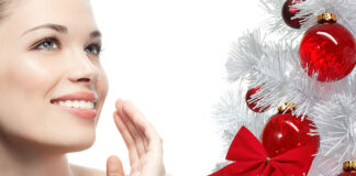 Piękna, młoda kobieta uśmiechająca się przy choince